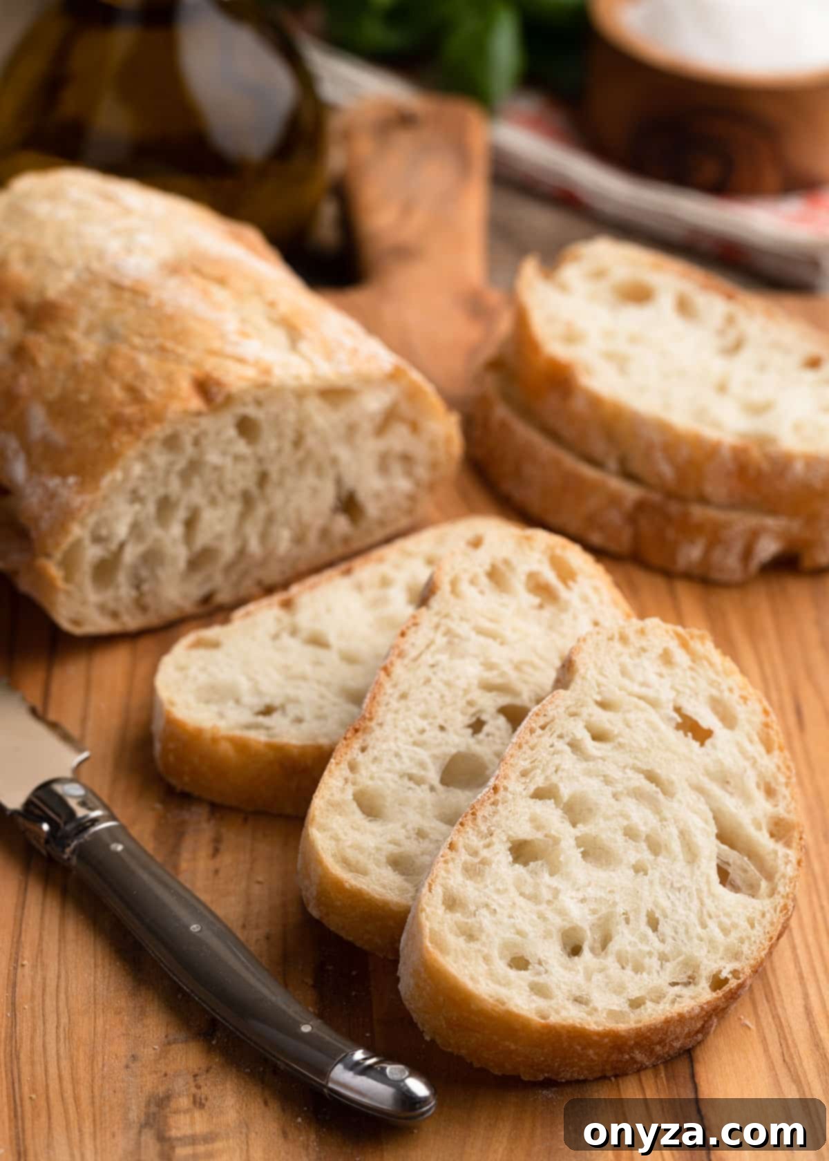 Fresh Cherry Tomato Bruschetta 7 sliced loaf of ciabatta bread on a wooden cutting board with a bread knife