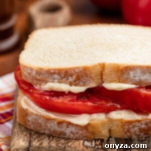 Sun-Kissed Southern Tomato Sandwich 9 Southern Tomato Sandwich on white bread with mayonnaise on a wooden serving board