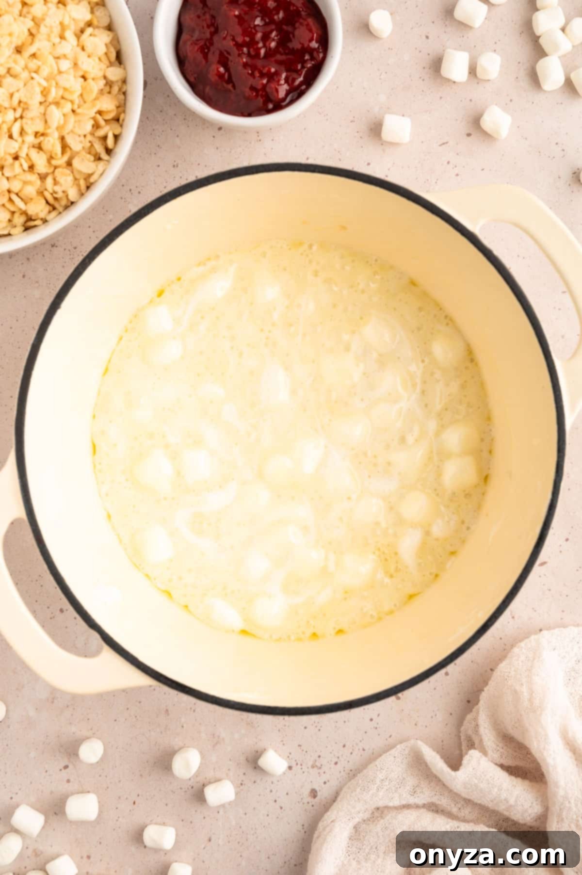 Sweet Strawberry Krispie Delights 4 Overhead view of mini marshmallows gently melting in rich butter within a white enameled cast iron pot