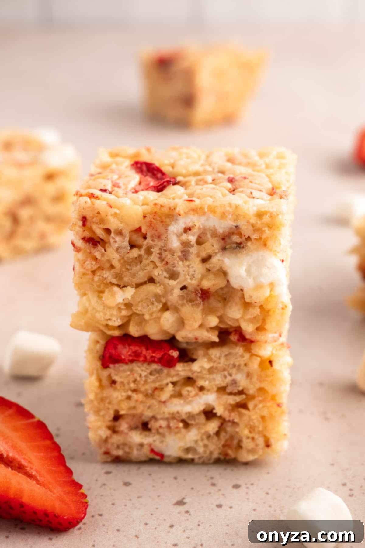 Sweet Strawberry Krispie Delights 9 Two perfectly cut Strawberry Rice Krispie Treats stacked one on top of the other, showcasing their vibrant color and texture