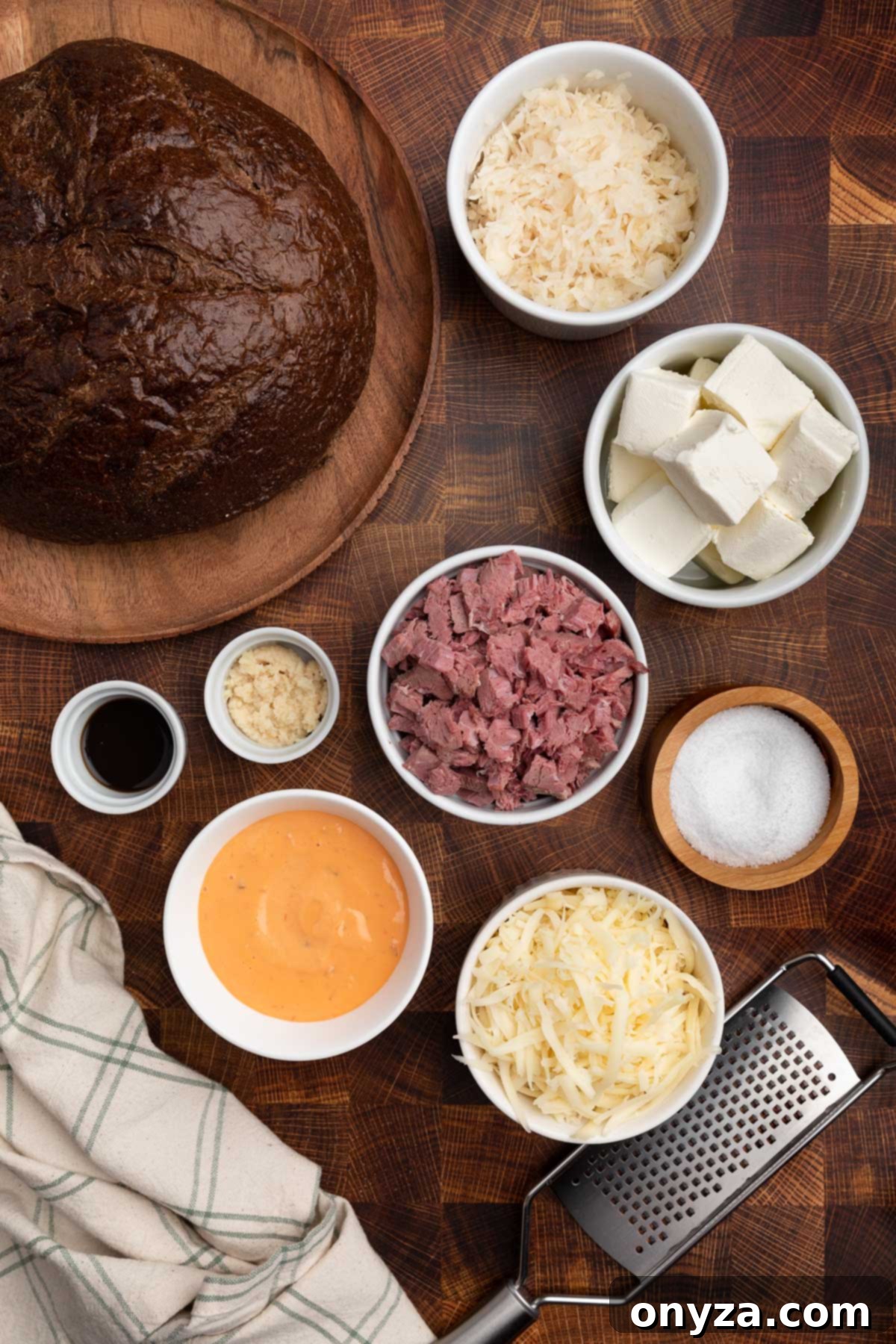 Irresistible Reuben Dip 3 overhead photo of ingredients needed to make reuben dip in bowls on a wood butcher block board
