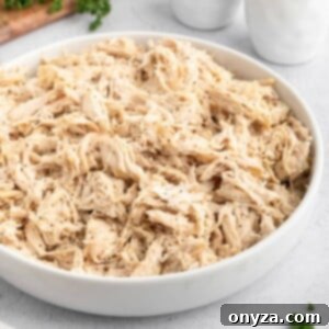 shredded chicken seasoned with black pepper in a white ceramic bowl