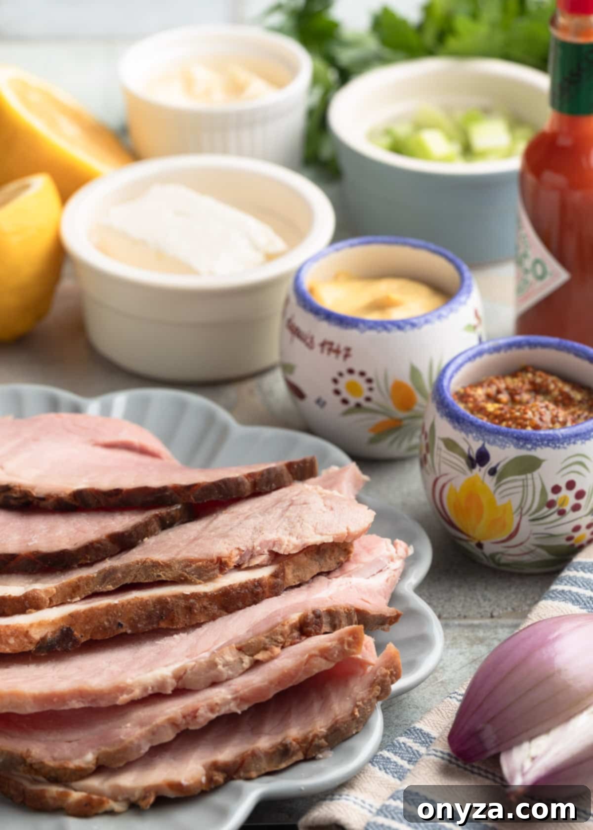 An organized overhead shot displaying all the fresh ingredients for deviled ham spread, neatly arranged on plates and in bowls on a stylish tile board, ready for preparation.