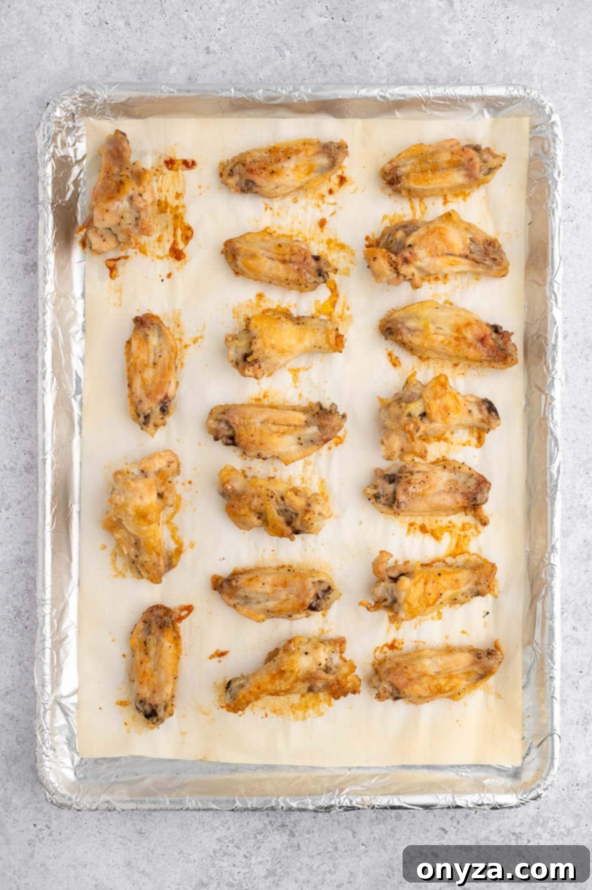 baked chicken wings on a parchment and foil lined baking sheet