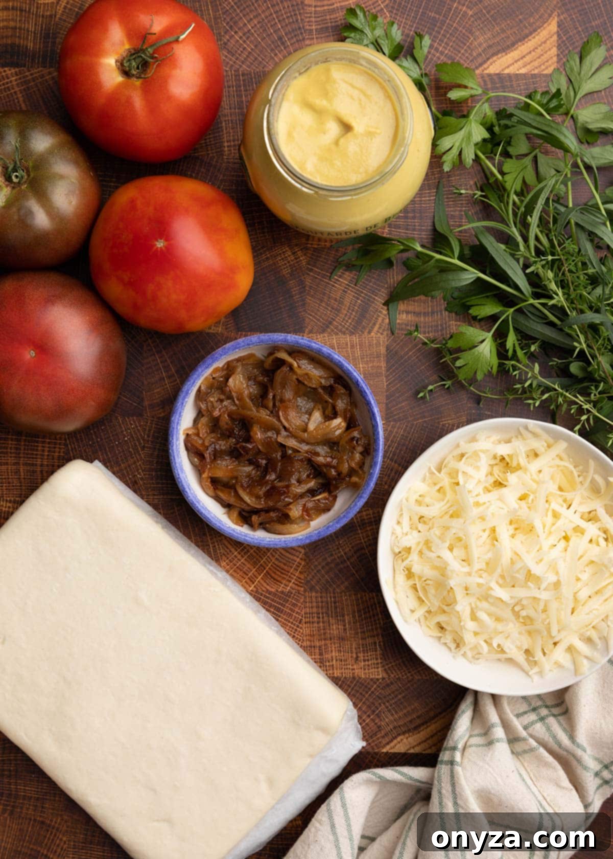 Flaky Tomato Tart 3 overhead photo of ingredients needed to make a puff pastry tomato tart on a wood cutting board