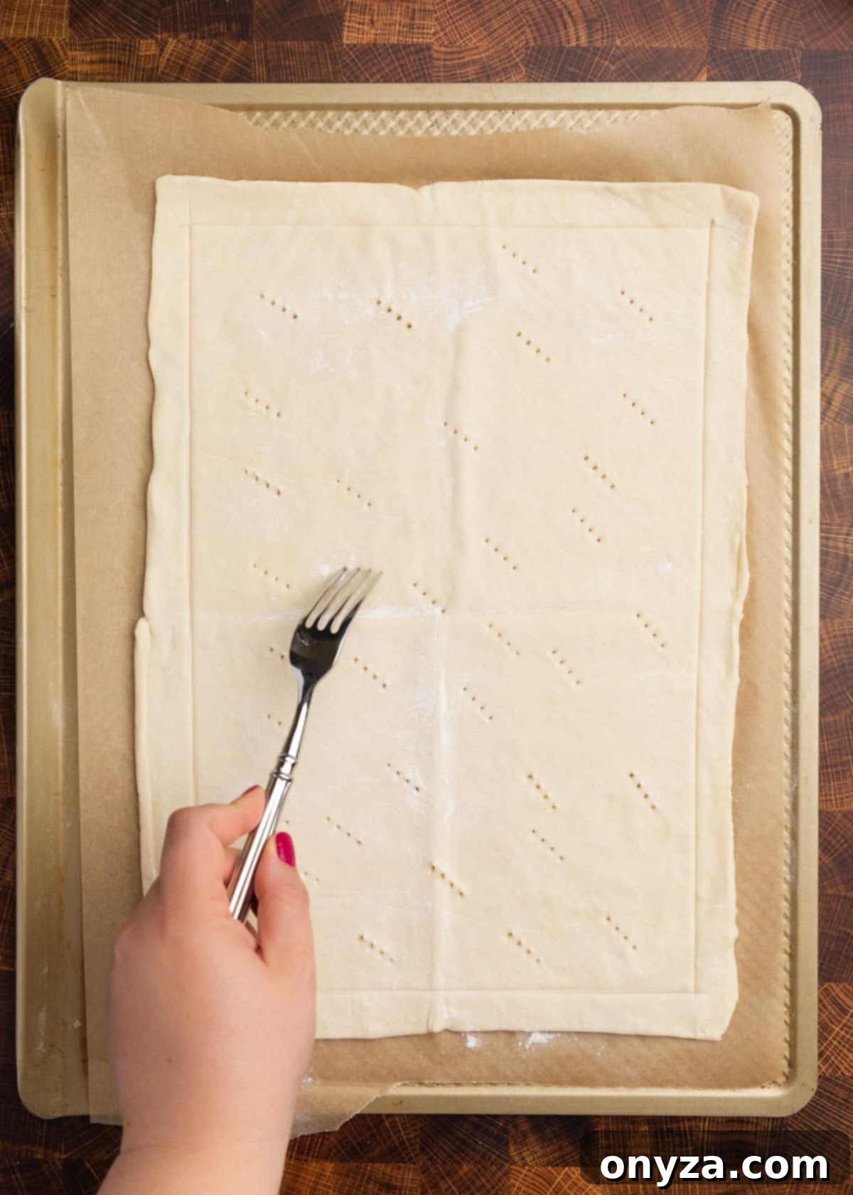 Flaky Tomato Tart 6 overhead photo of puff pastry on a parchment lined baking sheet being docked with a fork