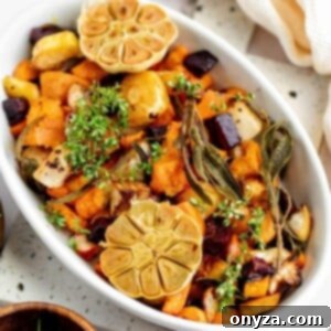 Roasted root vegetables in a white casserole dish, garnished beautifully.