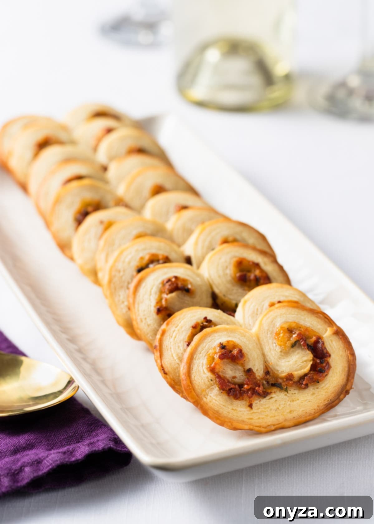 savory palmiers with bacon and gruyere on a white serving plate