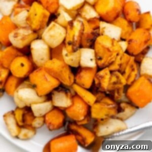 air fryer maple glazed root vegetables on a white platter with a stainless steel spoon