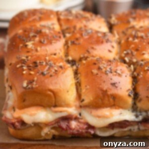 slab of Reuben sliders on Hawaiian buns on a wooden serving board
