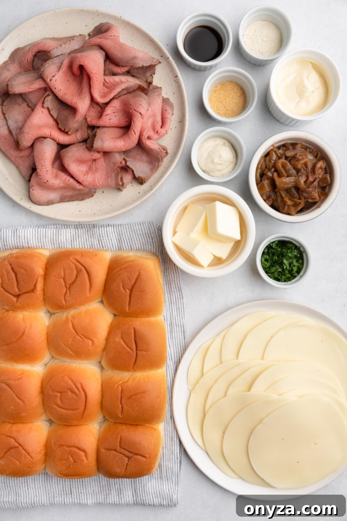 Savory French Dip Sliders 3 overhead photo of French Dip Slider ingredients in bowls on a white board