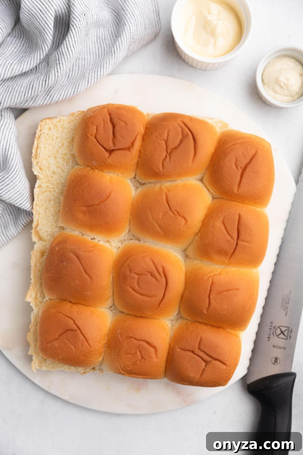 Savory French Dip Sliders 6 a slab of slider rolls sliced in half on a white marble board