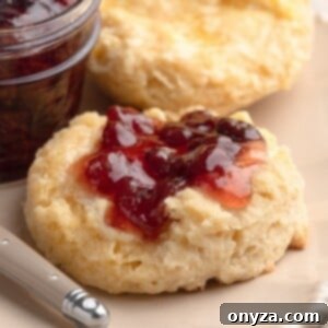 closeup of irish scone spread with butter and strawberry jam