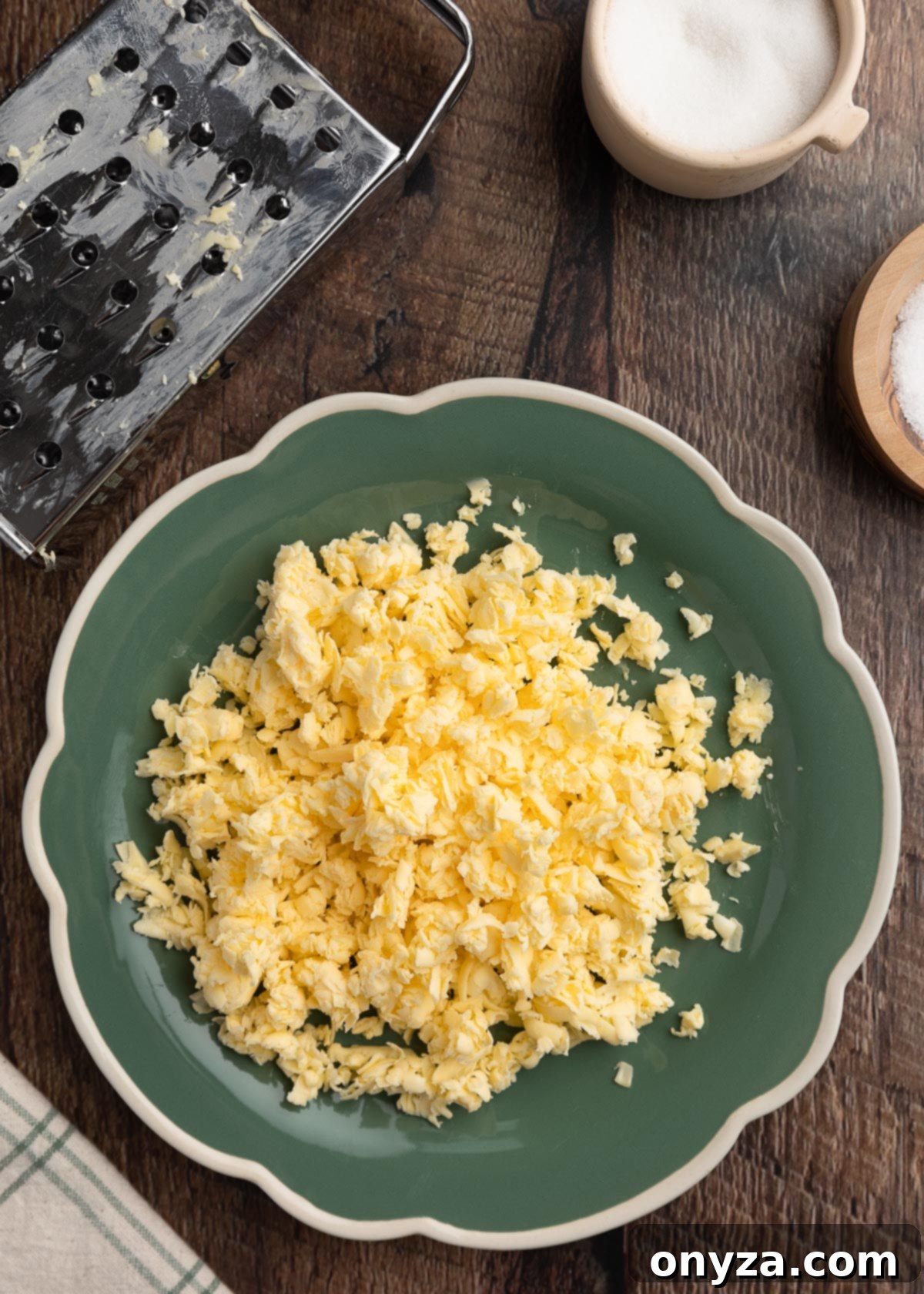 overhead photo of Kerrygold Irish butter grated on a green scalloped plate next to a cheese grater