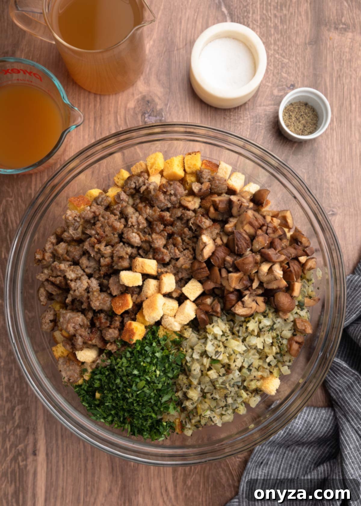 Festive Sausage and Chestnut Stuffing 12 overhead of a bowl of toasted cornbread and white bread cubes with browned crumbled sausage, quartered chestnuts, sauteed vegetables, and chopped parsley.