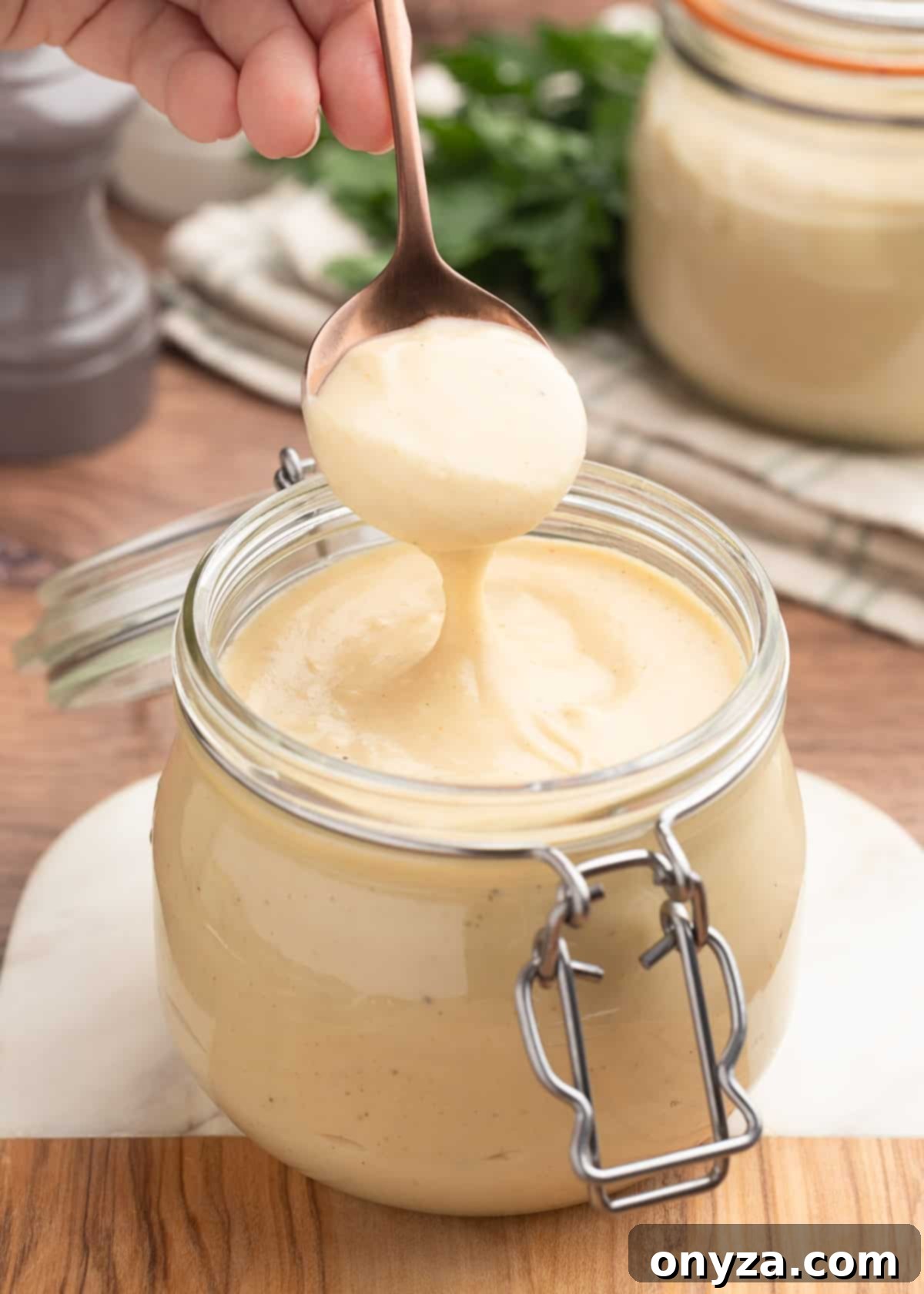 a spoonful of homemade condensed cream of chicken soup held over a glass jar of the soup