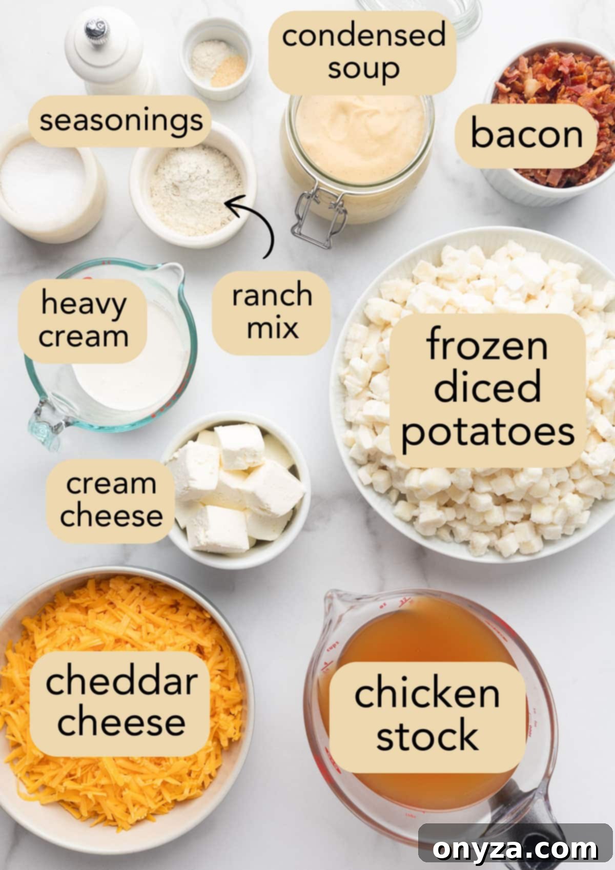 Overhead view of all the essential ingredients laid out in small bowls on a white marble surface, clearly labeled for making Crockpot Hashbrown Potato Soup.