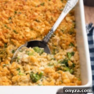 Creamy Chicken Broccoli Rice Casserole in a white baking dish with a silver serving spoon, ready to be enjoyed.