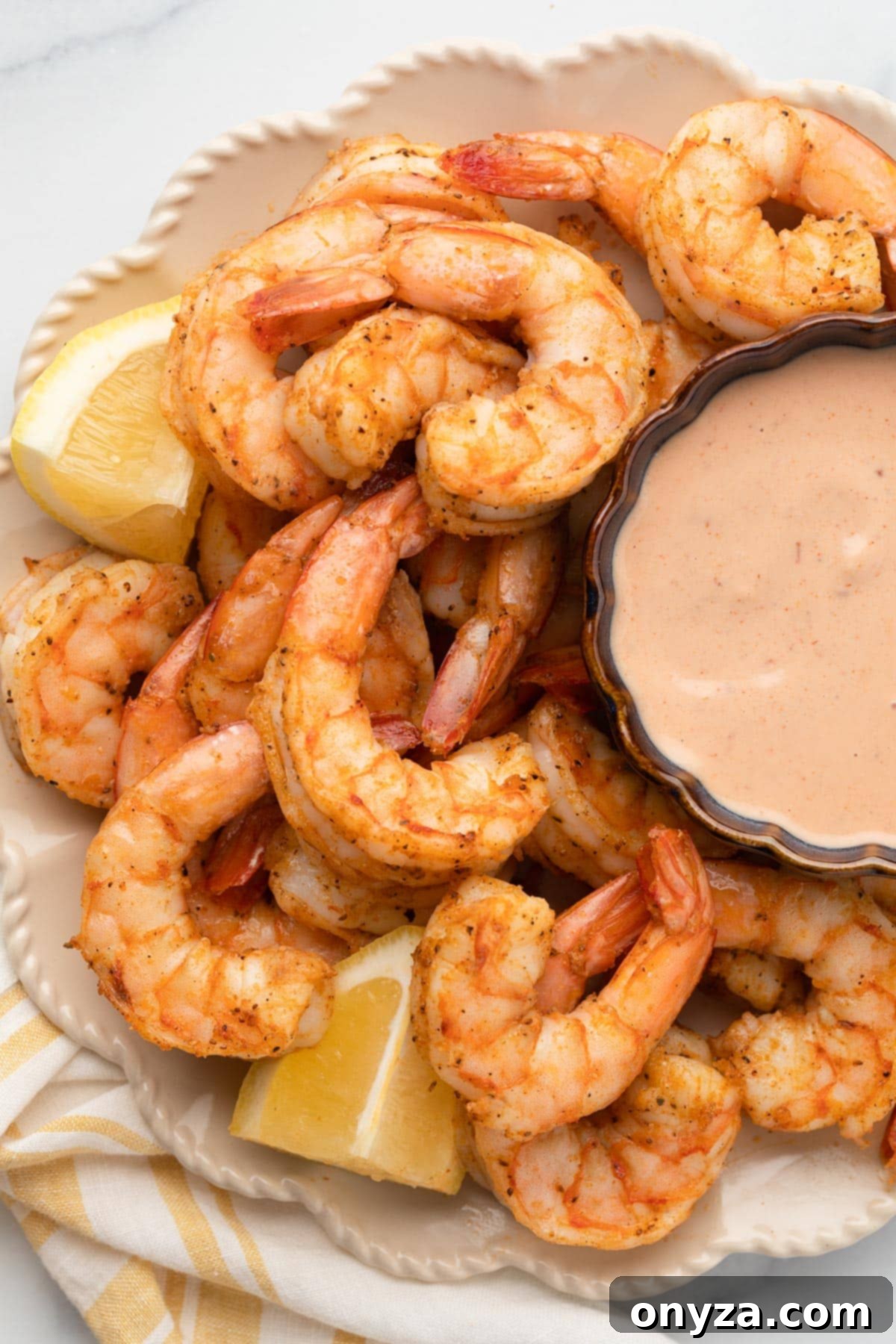 Crispy Air Fryer Shrimp 11 overhead of a platter of air fryer shrimp with lemon wedges and a bowl of dipping sauce