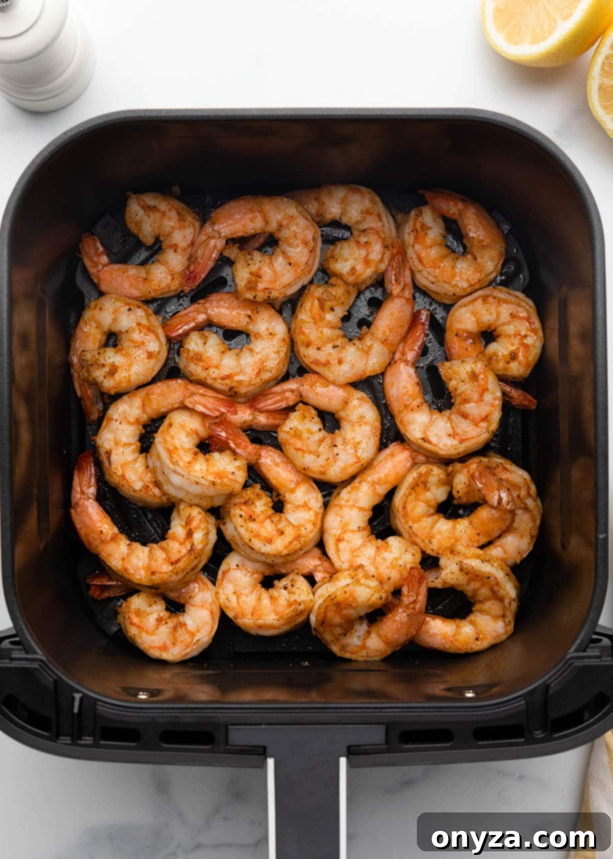 Crispy Air Fryer Shrimp 9 cooked seasoned shrimp in a square XL air fryer basket