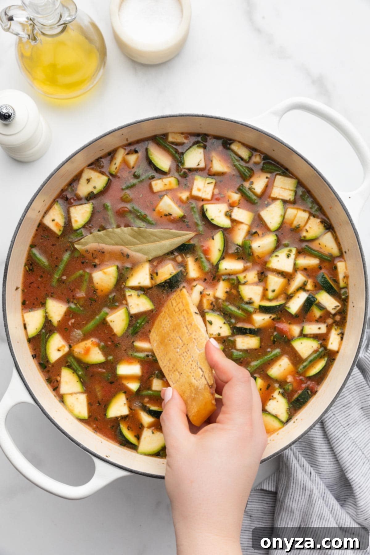 Adding a Parmigiano Reggiano rind to an uncooked pot of Minestrone Soup to infuse flavor.