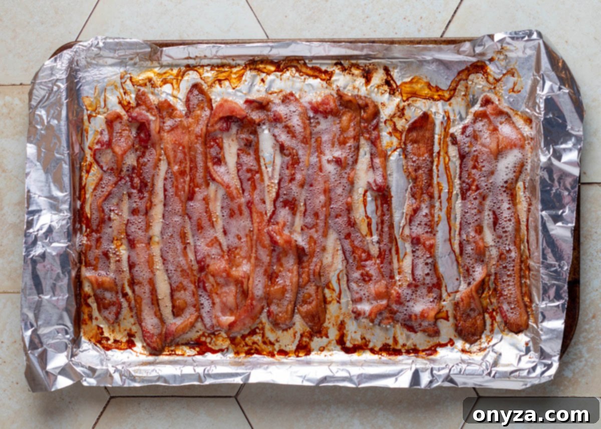 Savory Spinach & Pea Salad with Crispy Bacon and Sausage 8 Overhead view of perfectly baked, crispy bacon on a foil-lined baking sheet.