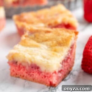 Strawberry chess squares on a white marble surface, showcasing their appealing golden-brown topping and gooey interior.