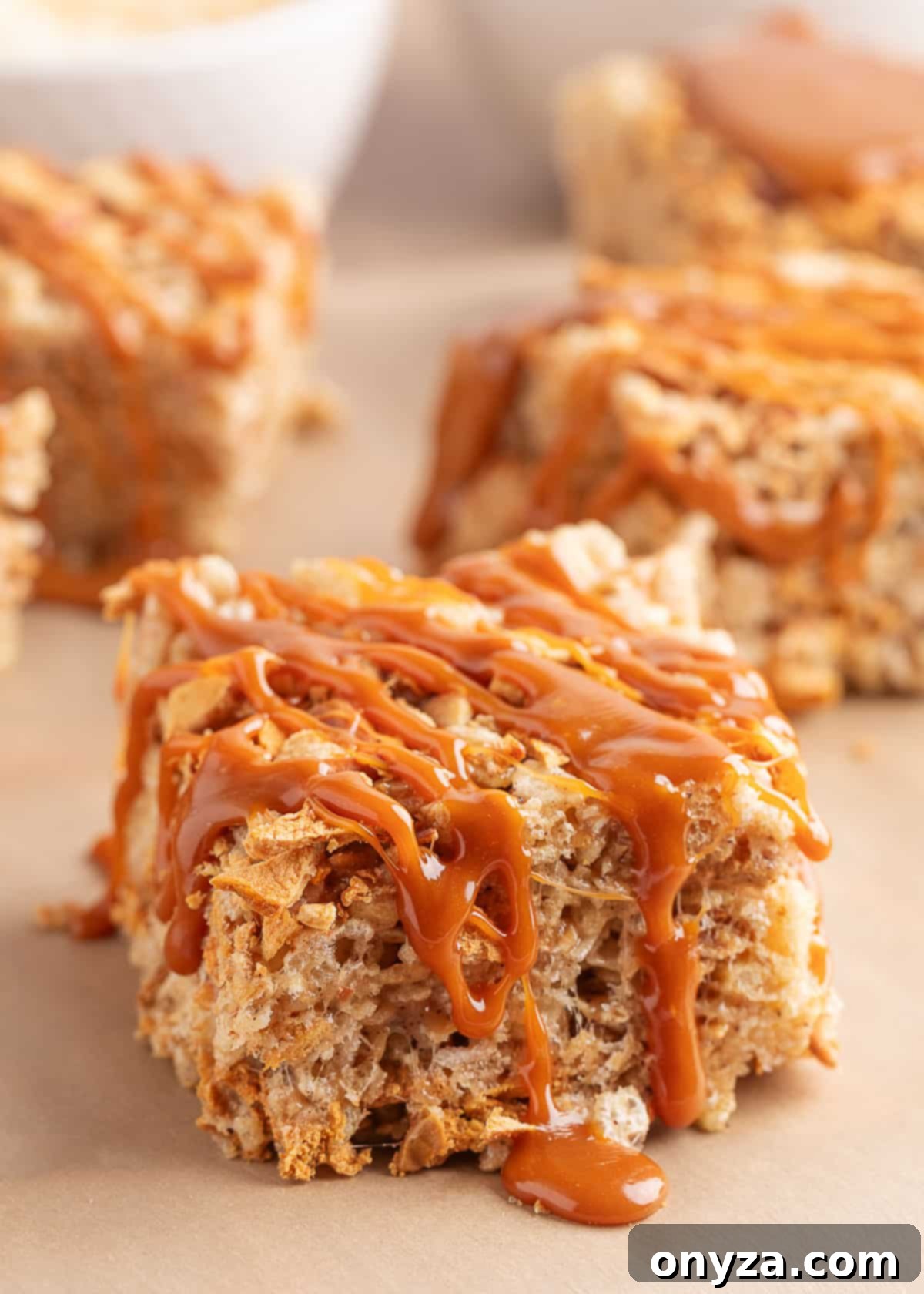 caramel drizzled apple pie rice krispies treats on parchment paper