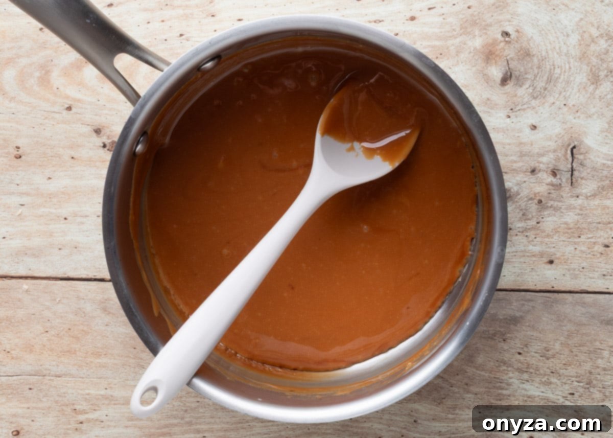 melted caramel sauce in a pot with a white spoon