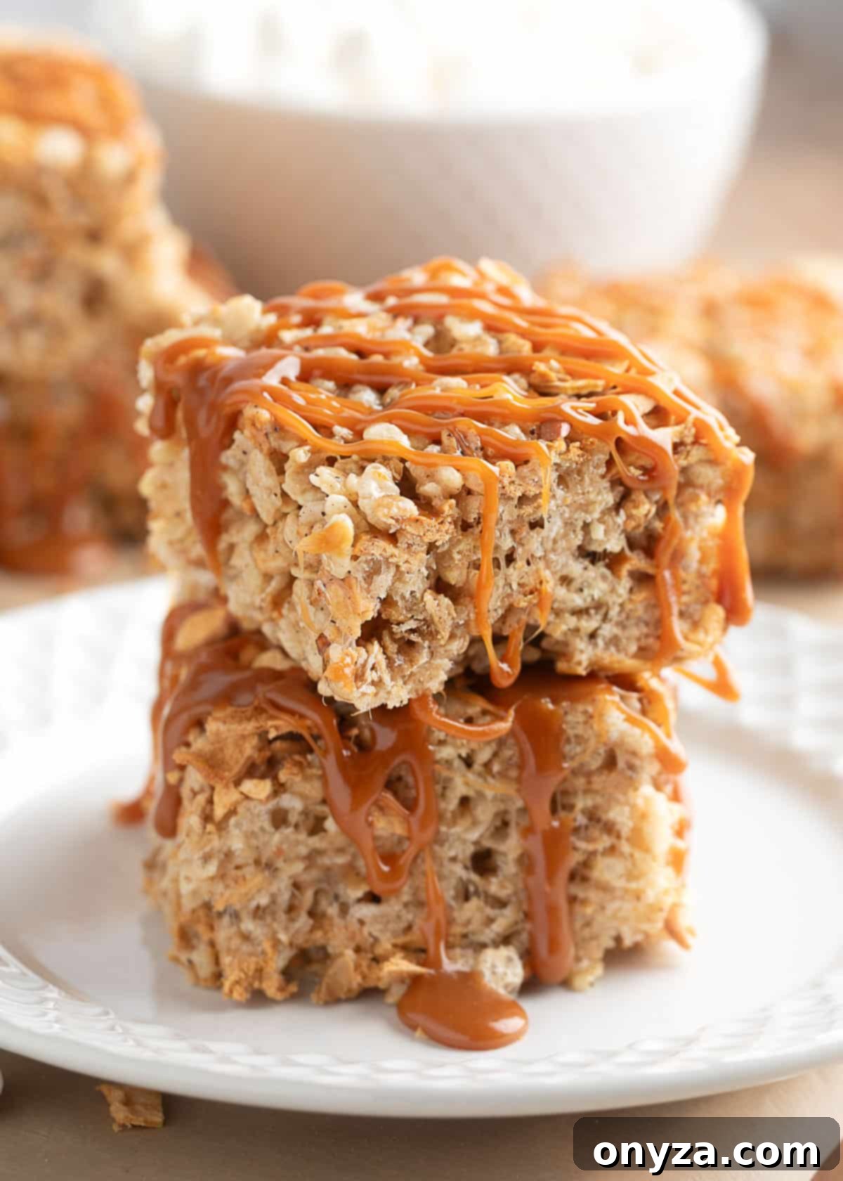 two caramel apple pie rice krispies treats stacked on a white plate