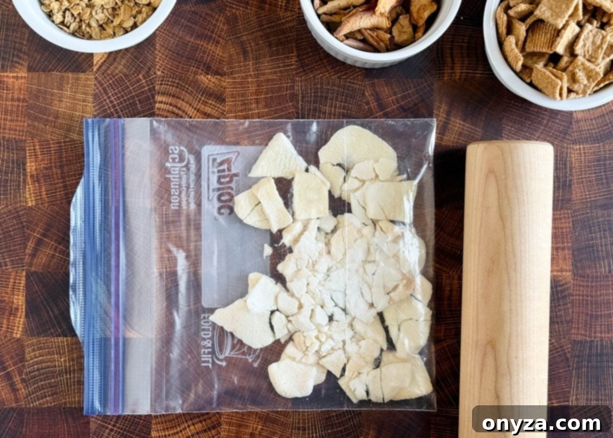 overhead of freeze dried apples in a ziplock bag next to a rolling pin