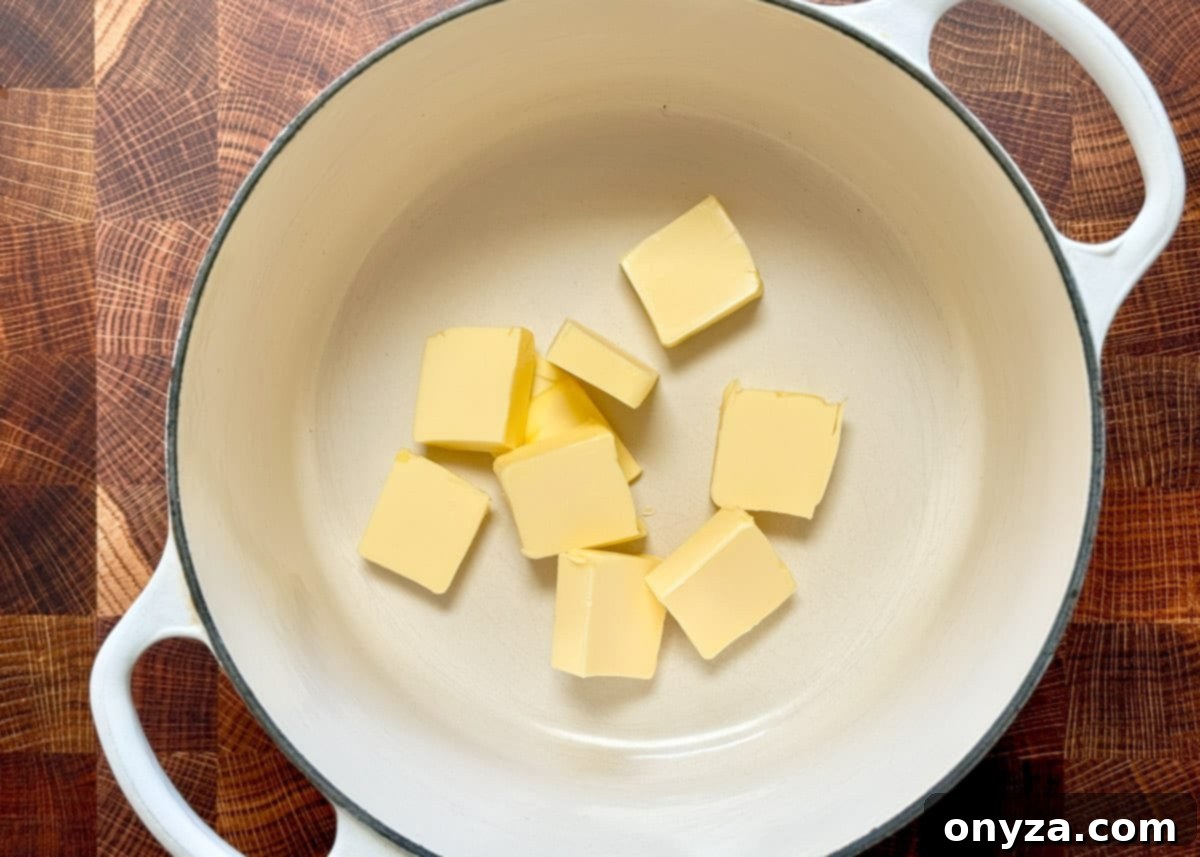 cubes of butter in a white enameled cast iron pot