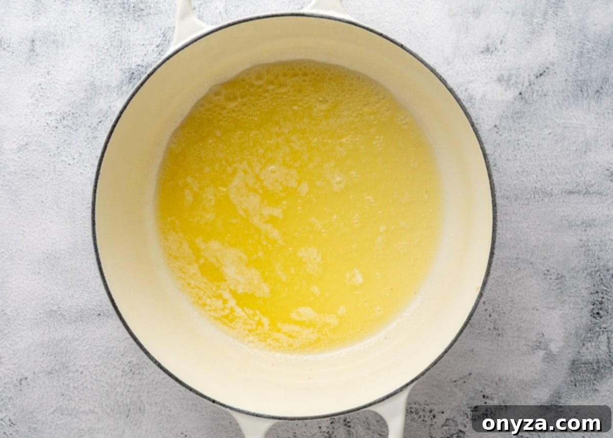 overhead of melted butter in a white enameled cast iron pot