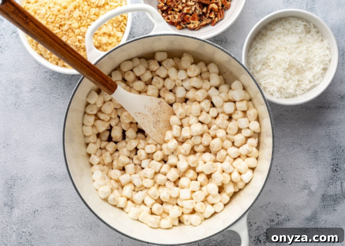 mini marshmallows added to a pot of brown butter with a wood handled spatula
