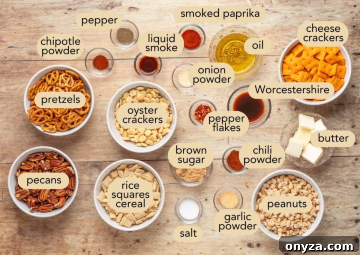 Flat lay of BBQ snack mix ingredients labeled in bowls and jars on a wooden surface. Visible ingredients include cheese crackers, pretzels, rice squares cereal, oyster crackers, peanuts, pecans, and spices such as chili powder, smoked paprika, garlic powder, chipotle powder, onion powder, and black pepper, along with Worcestershire, brown sugar, butter, and oil.