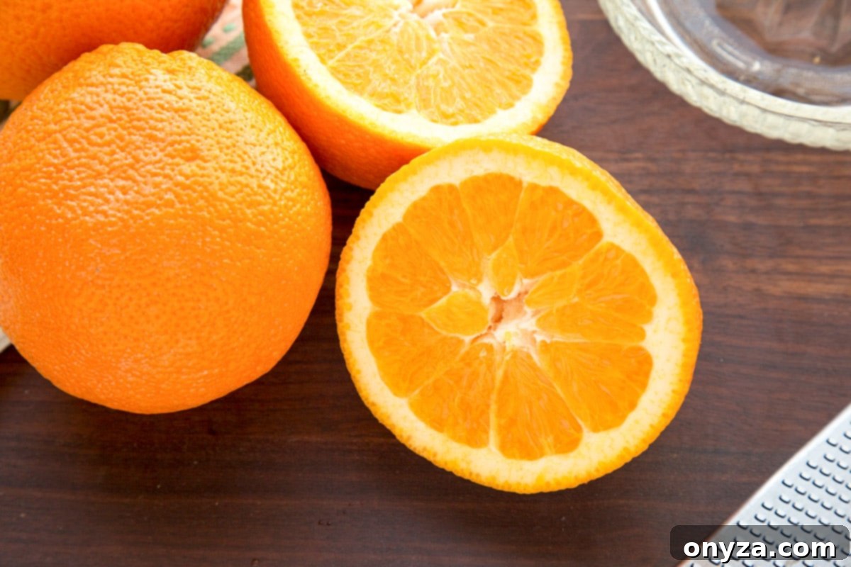 Whole and halved fresh oranges and lemons on a dark wooden cutting board, highlighting the fresh citrus for the curd.