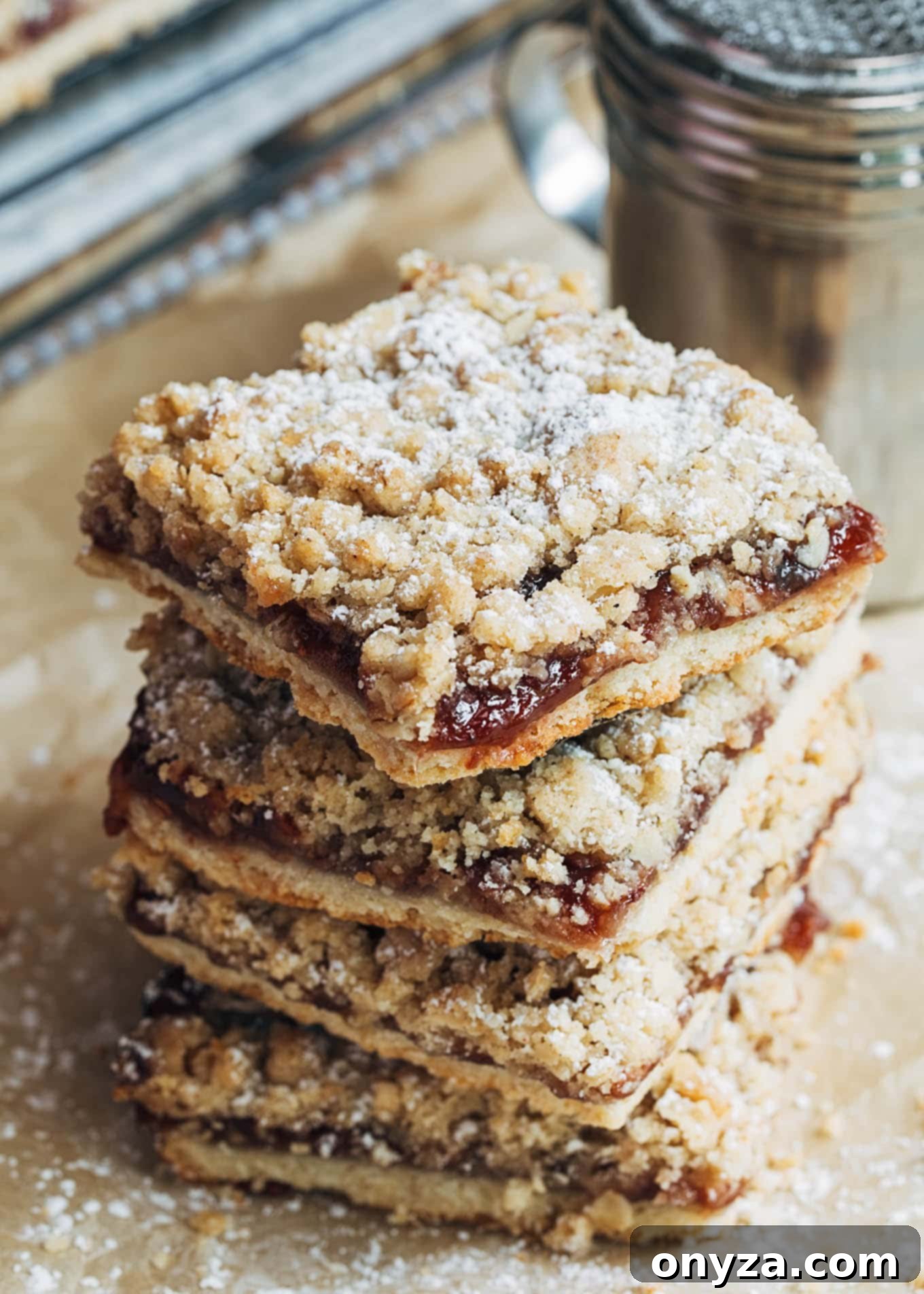 Stack of golden-brown jam bars with a visible oat crumble topping and fruit preserve filling