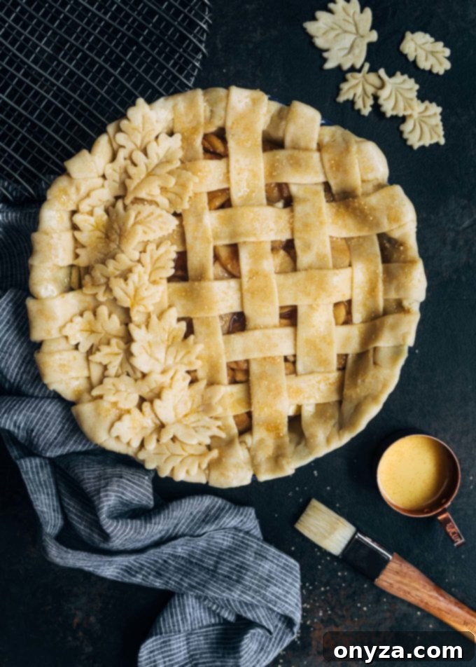 unbaked lattice apple pie with an egg wash applied using a pastry brush, ready for the oven