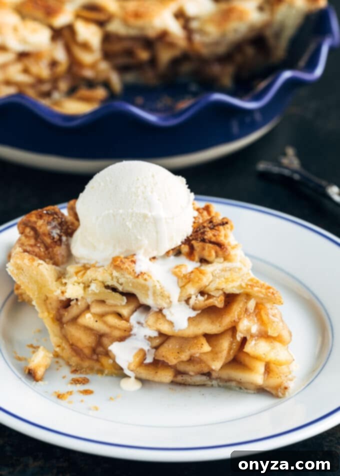 a slice of homemade apple pie with a scoop of vanilla ice cream melting slightly on the side