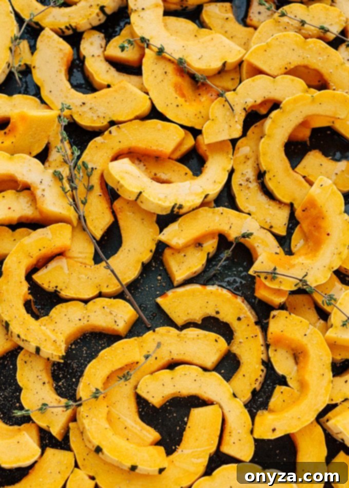 raw delicata squash rings on baking sheet with thyme