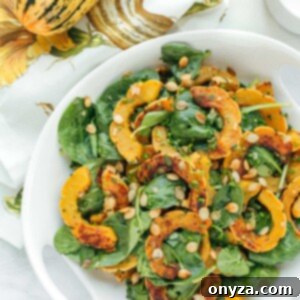 delicata squash salad with baby spinach and brown butter vinaigrette in a white serving bowl