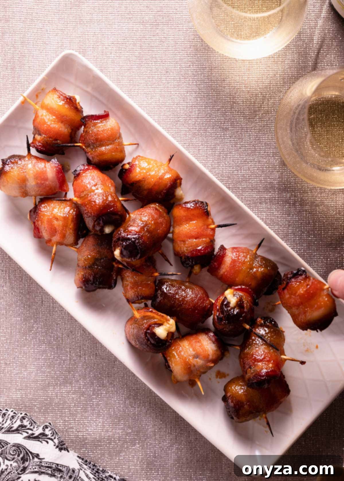 An overhead view of a beautiful platter filled with perfectly cooked bacon-wrapped and blue cheese stuffed dates, ready to be enjoyed.
