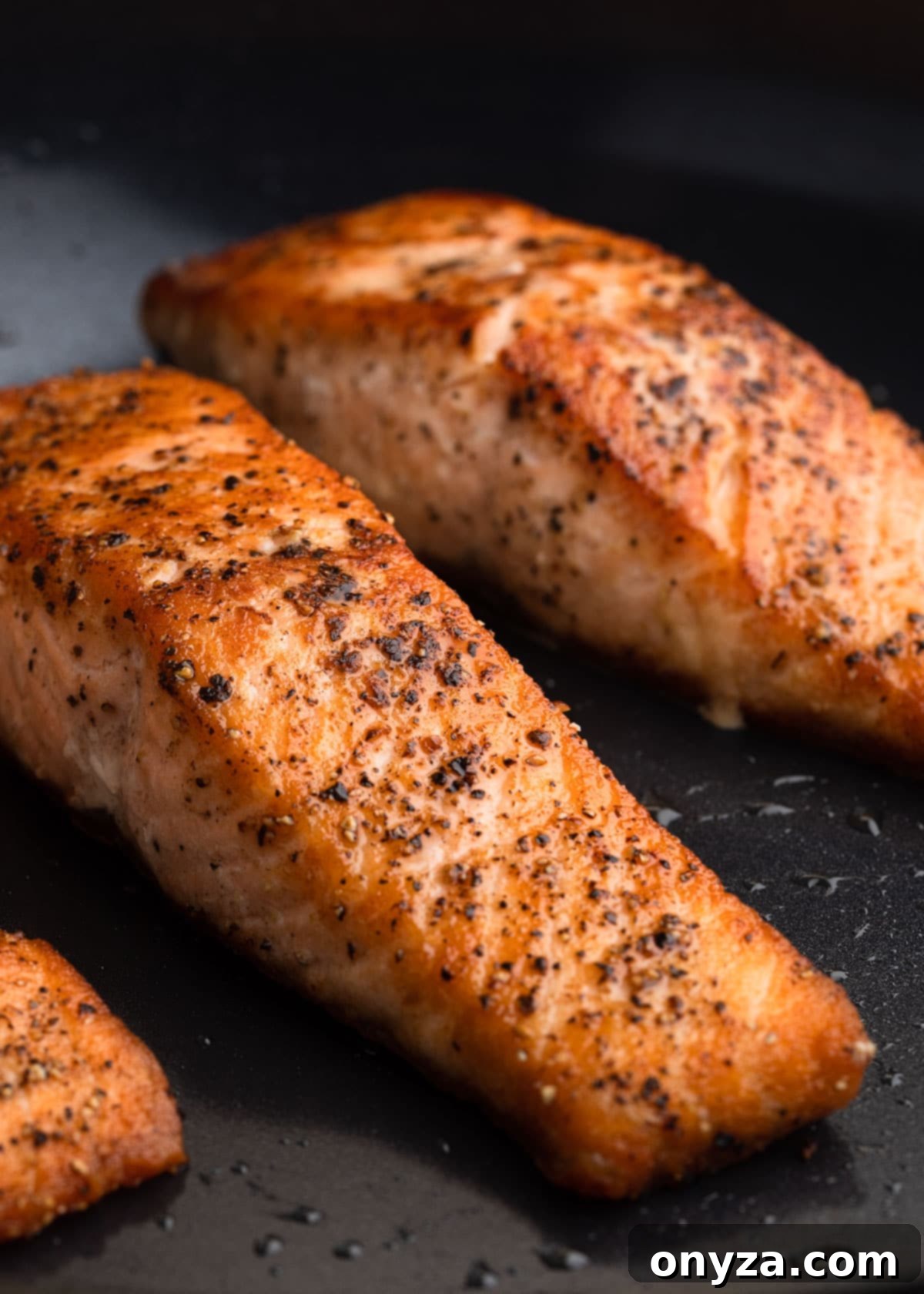Flaked Salmon Couscous Salad with Sun-Kissed Tomato Vinaigrette 5 Pan-seared salmon fillets cooking in a nonstick pan, showing crispy skin