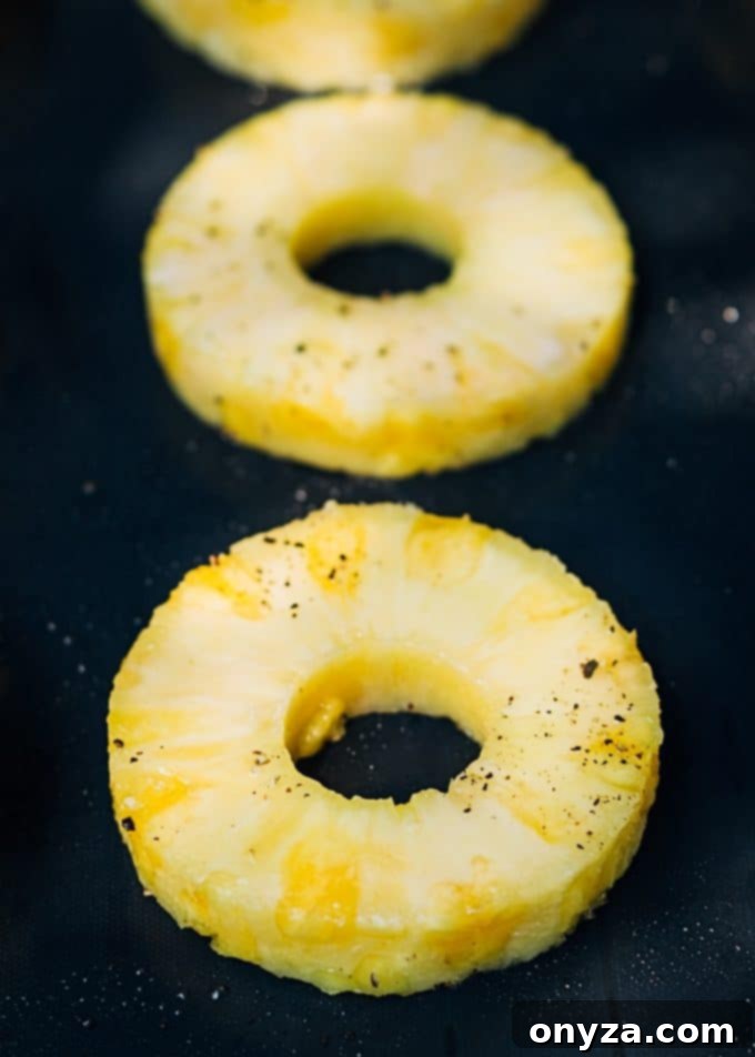 Sweet & Smoky Grilled Pineapple Salsa 3 Slices of fresh pineapple arranged on a nonstick grill mat, ready for grilling