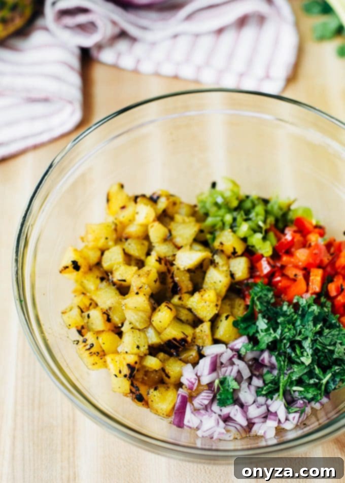Sweet & Smoky Grilled Pineapple Salsa 5 Grilled pineapple, bell peppers, onions, and cilantro being mixed in a large bowl to create the salsa