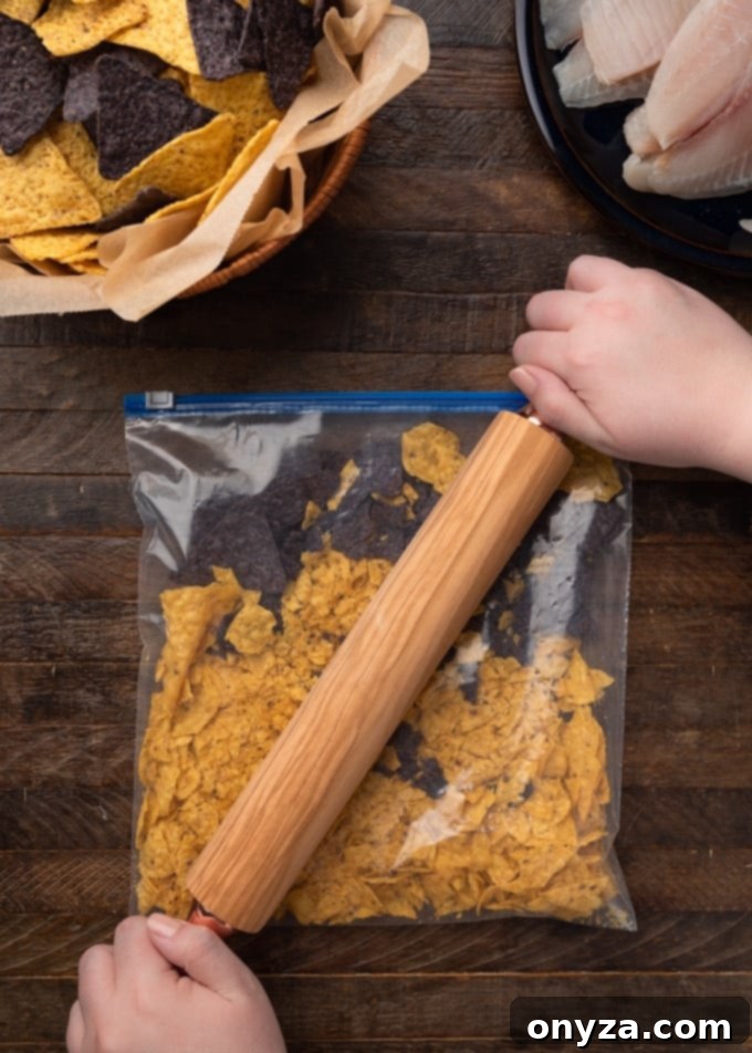 Crispy Tortilla Tilapia 5 Crushing tortilla chips in a plastic bag with a rolling pin