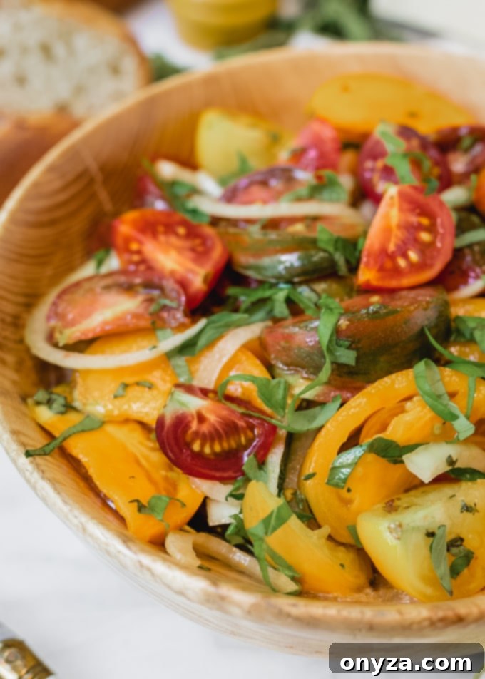 Side view of fresh tomato salad with slices of Italian bread on a marble board, ready for serving