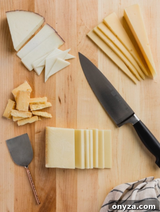 Sliced blocks of hard cheese arranged on a wooden cutting board with a large chef's knife and a smaller cheese knife, illustrating pre-cutting techniques.