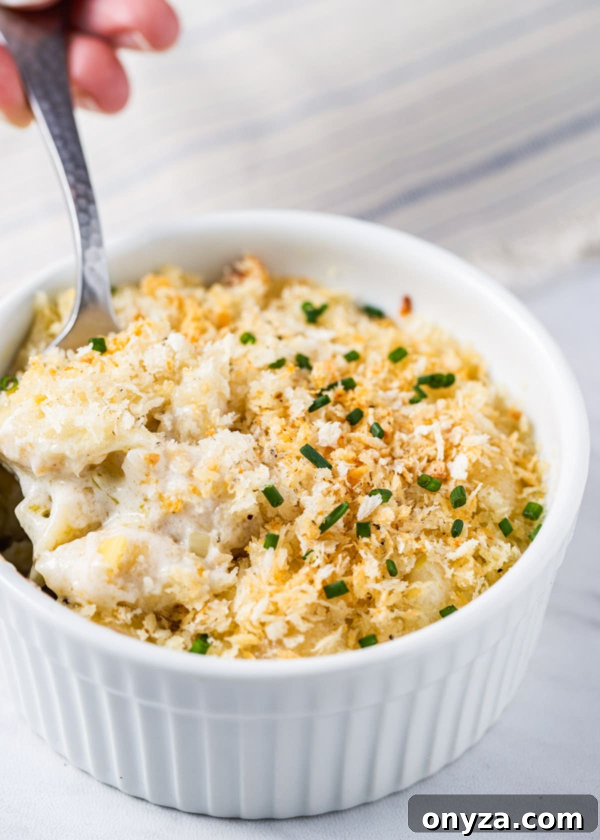 gourmet mac and cheese made with gorgonzola and fontina in a white ramekin with a spoon