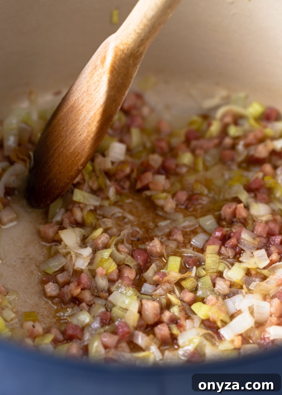 sauteeing leeks and pancetta in an enameled cast iron pot